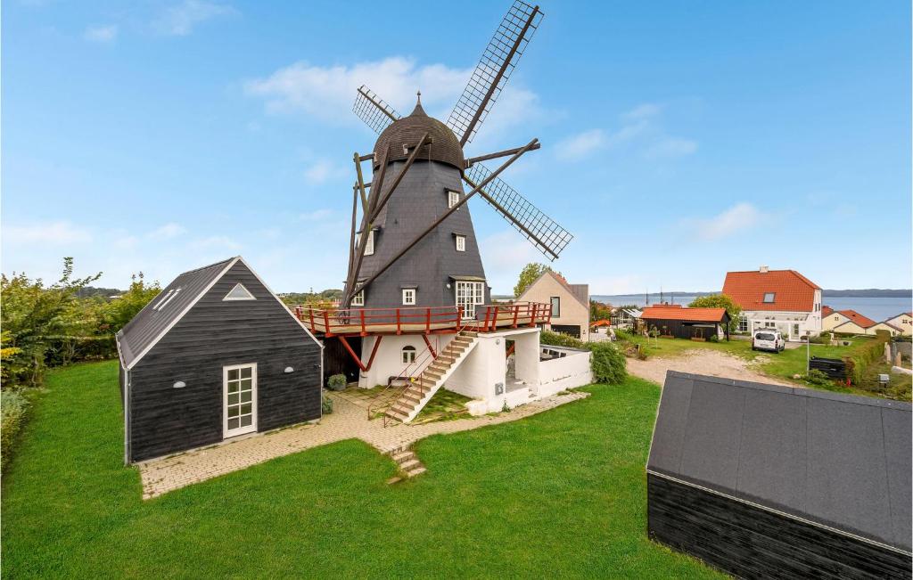 eine Windmühle mit einem Gebäude und einem Haus in der Unterkunft Mllen in Ebeltoft