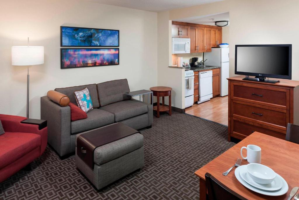 sala de estar con sofá y TV en TownePlace Suites Suffolk Chesapeake, en Suffolk