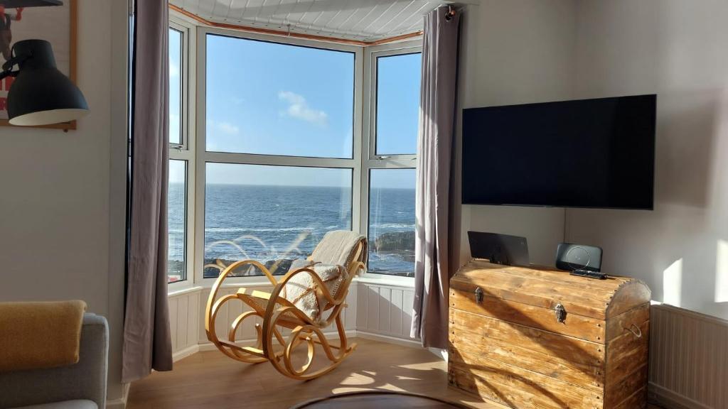 a living room with a large window with a view of the ocean at The Cranny, Portstewart in Portstewart