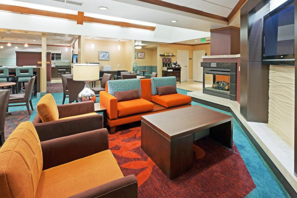 a lobby with orange chairs and a fireplace at Residence Inn Boulder Longmont in Longmont