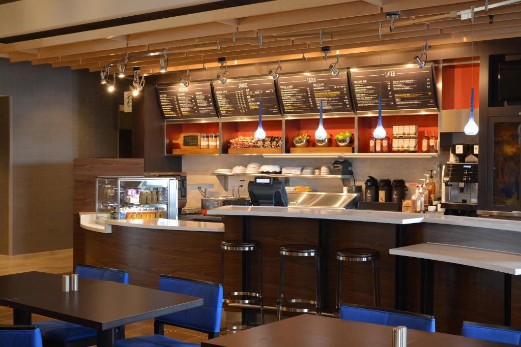 a restaurant with a bar with tables and chairs at Courtyard by Marriott Youngstown Canfield in Canfield