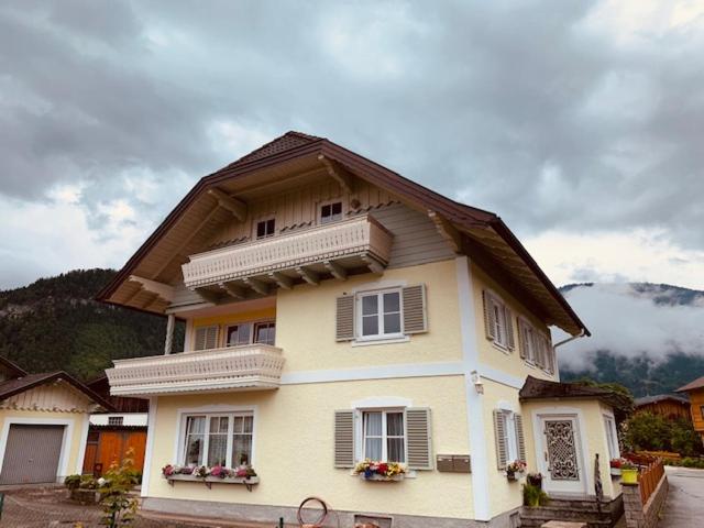 une grande maison blanche avec un toit en gambrel dans l'établissement Apartment Brigitte Schöndorfer, à Strobl