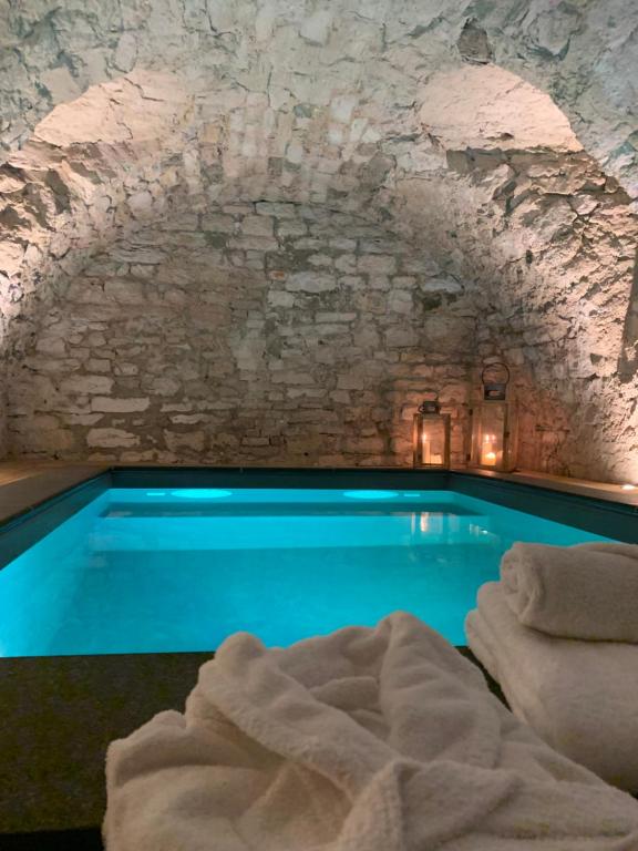 einen Pool in einer Höhle mit einer Steinmauer in der Unterkunft Chambres d'hôtes du château in Boulogne-sur-Mer