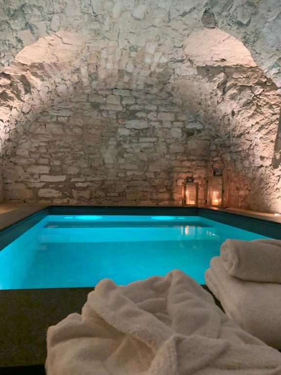 a swimming pool in a cave with a stone wall at Chambres d'hôtes du château in Boulogne-sur-Mer