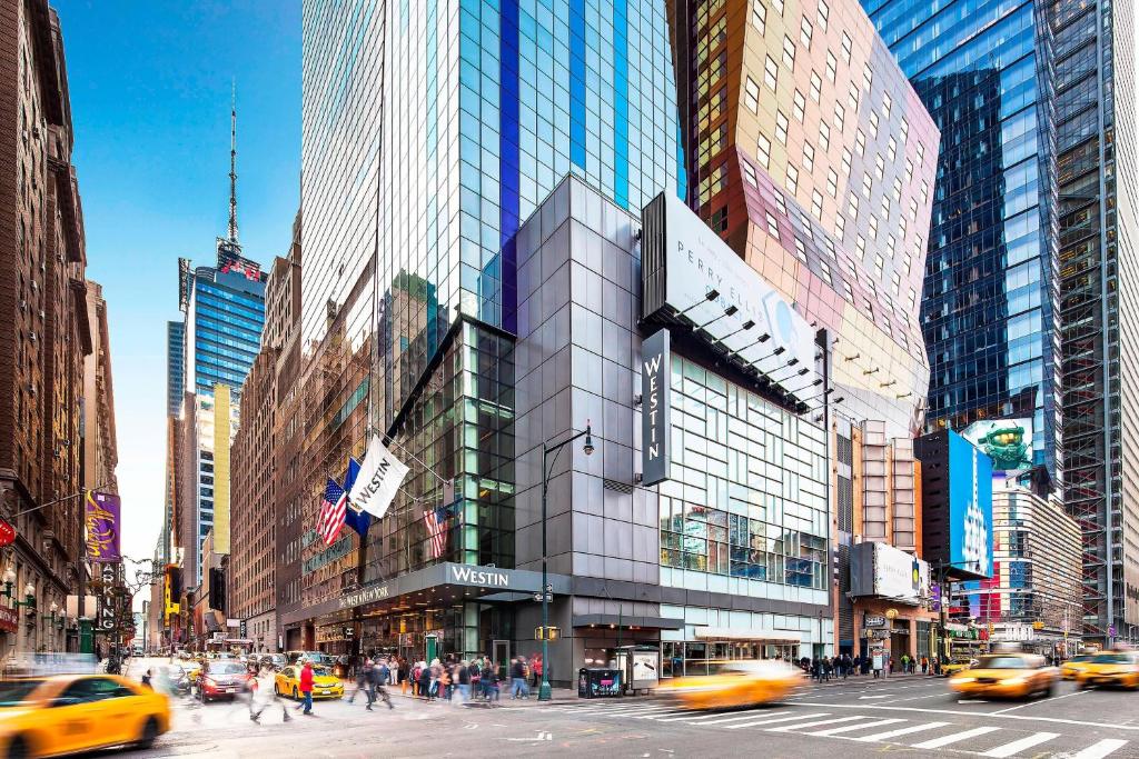 een drukke straat met verkeer en taxi's voor een gebouw bij The Westin New York at Times Square in New York