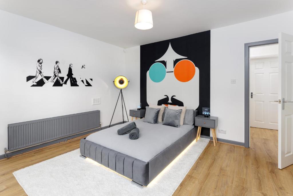 FLATZY - Iconic Beatles and Liverpool Culture Home في ليفربول: غرفة نوم بسرير مع لوحة على الحائط