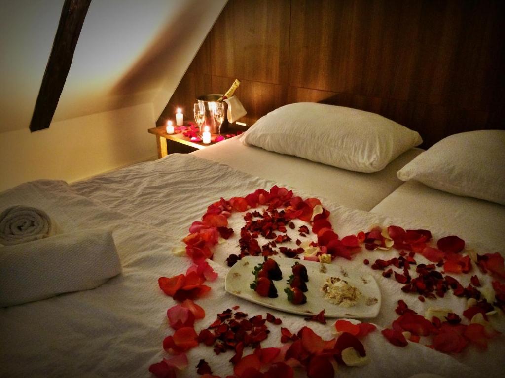 ein Bett mit roten Rosen drauf mit einem Teller Essen in der Unterkunft Bokun Apartments I in Sisak