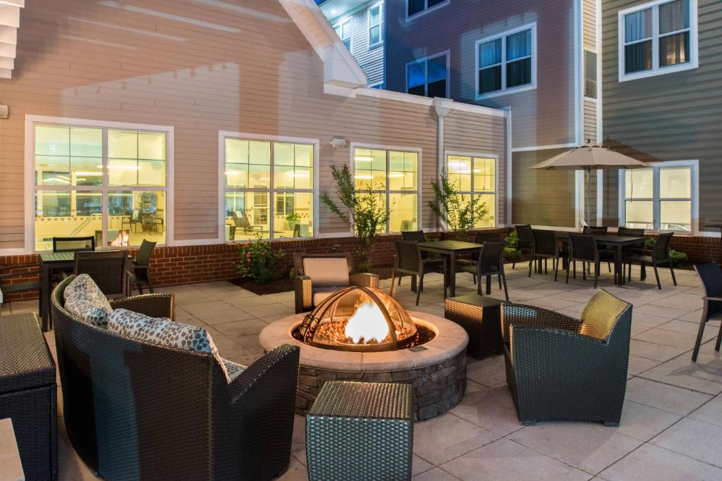 eine Terrasse mit einer Feuerstelle mit Stühlen und Tischen in der Unterkunft Residence Inn by Marriott Harrisonburg in Harrisonburg