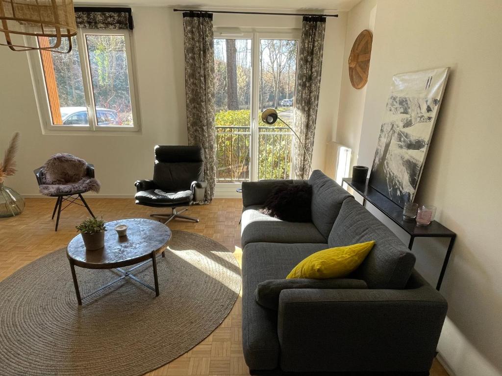 a living room with a couch and a table at Très bel appartement T3 centre ville, commerces et gare in Rambouillet