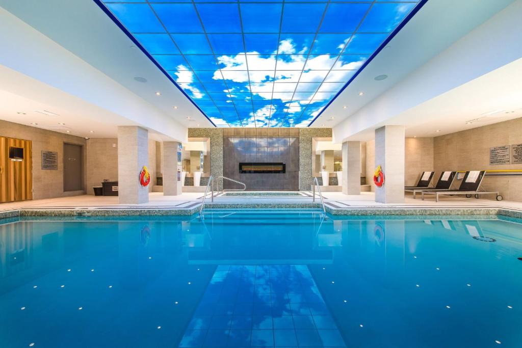 a large swimming pool in a hotel with a ceiling at Delta Hotels by Marriott Waterloo in Waterloo