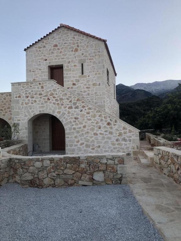 un gran edificio de piedra con una pared de piedra en Villa Asteria, en Melidhónion