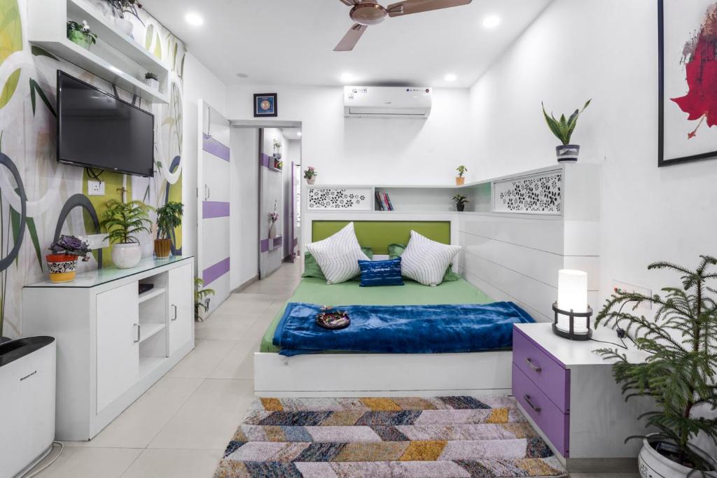 ニューデリーにあるHomlee-Heritage 2-Bed Room Apt near Pragati Maidanのベッド1台とテレビが備わる客室です。