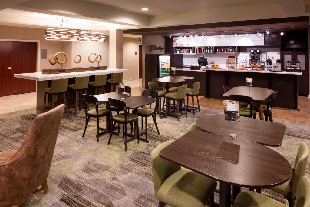 a restaurant with tables and chairs and a bar at Courtyard by Marriott Pensacola in Pensacola