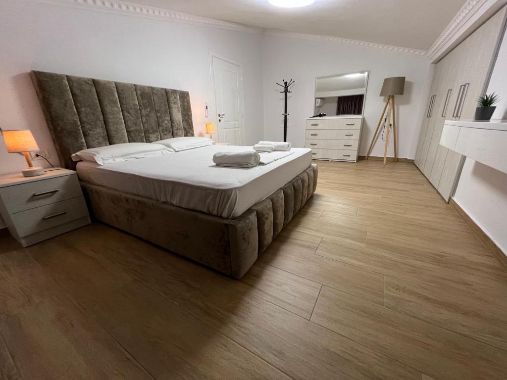 1 dormitorio con 1 cama grande y suelo de madera en Apartment Elbasan city center 2 en Elbasan