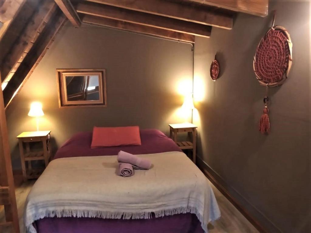 1 dormitorio con 1 cama con manta morada en Complejo Aiken en Villa Traful