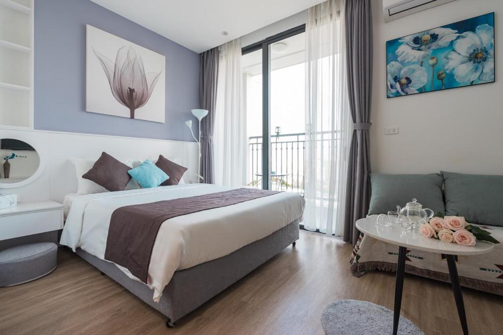 une chambre avec un grand lit et une table avec un canapé dans l'établissement NK#Homestay#Greenbay#Studio#C3, à Hanoï