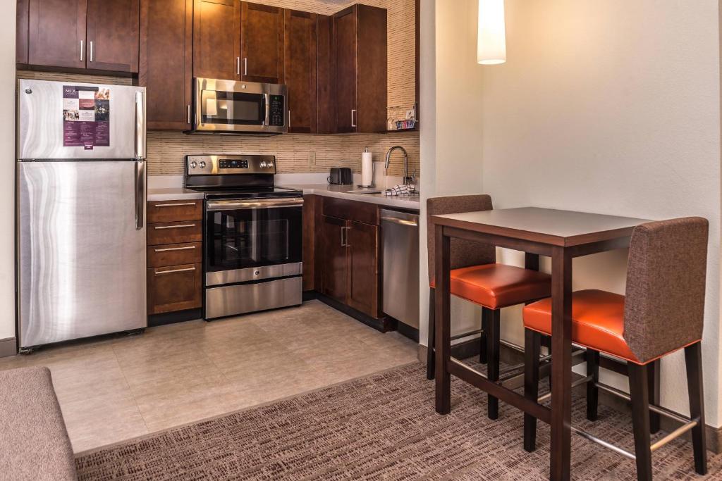 a kitchen with stainless steel appliances and a table at Residence Inn by Marriott St. Louis Westport in Maryland Heights