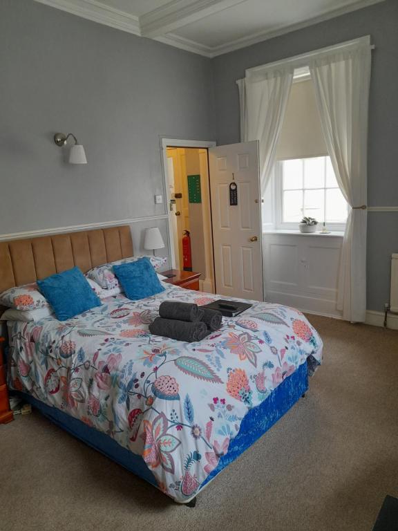 a bedroom with a large bed and a window at Valentine Guest House in Weymouth