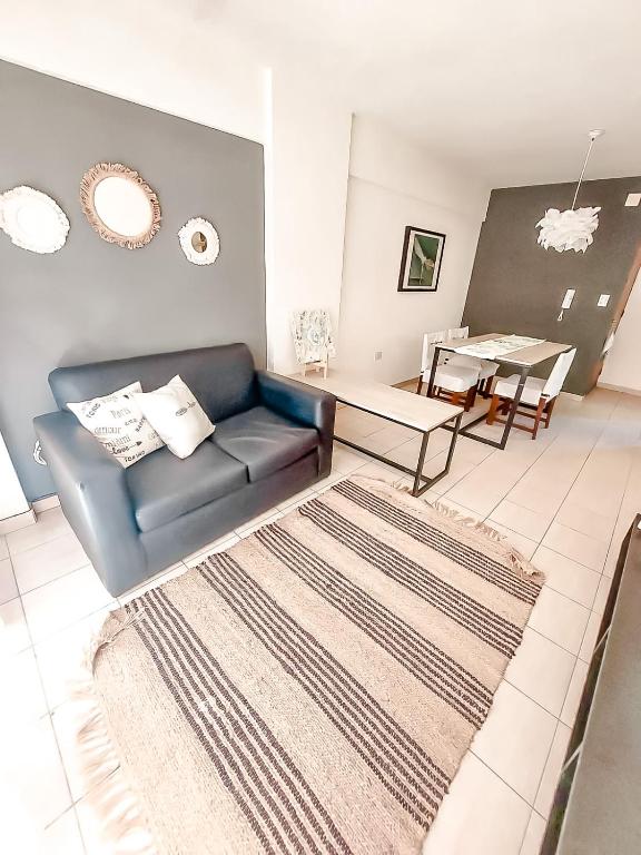 ein Wohnzimmer mit einem Sofa und einem Tisch in der Unterkunft Hermoso Departamento amplio con BALCÓN in Cordoba