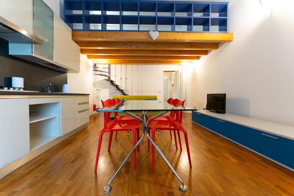 een keuken met een tafel en twee rode stoelen bij Apartment Sant'Alessandro 19 - Sostify in Bergamo