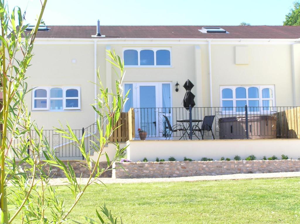 a white house with blue windows and a yard at Willow cottage, romantic retreat near Honiton Devon in Honiton