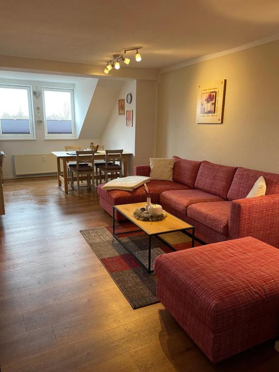 a living room with a red couch and a table at Altstadt Apartment Augustiner in Erfurt