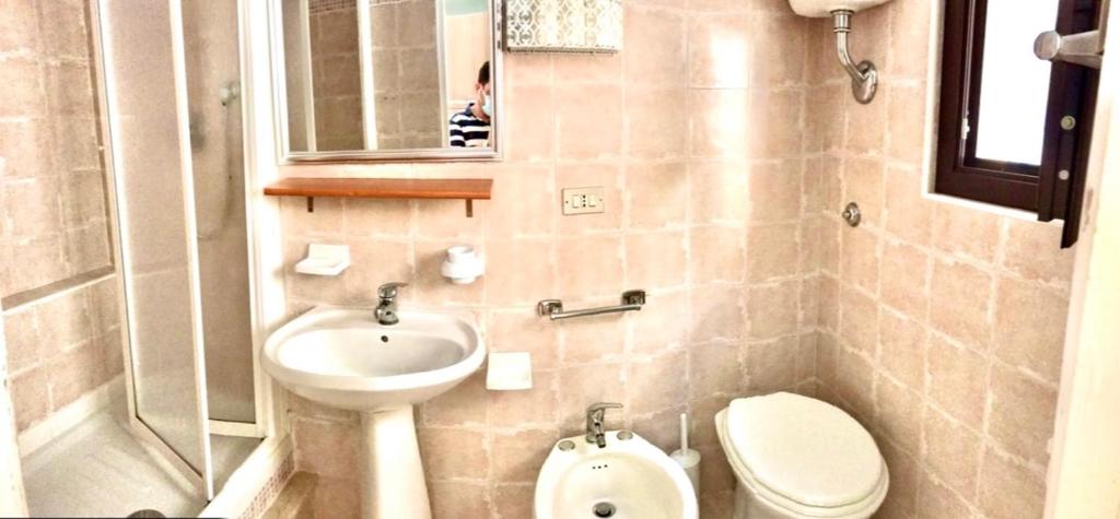 bagno con lavandino, servizi igienici e specchio di Carbonari Holiday House a Cefalù