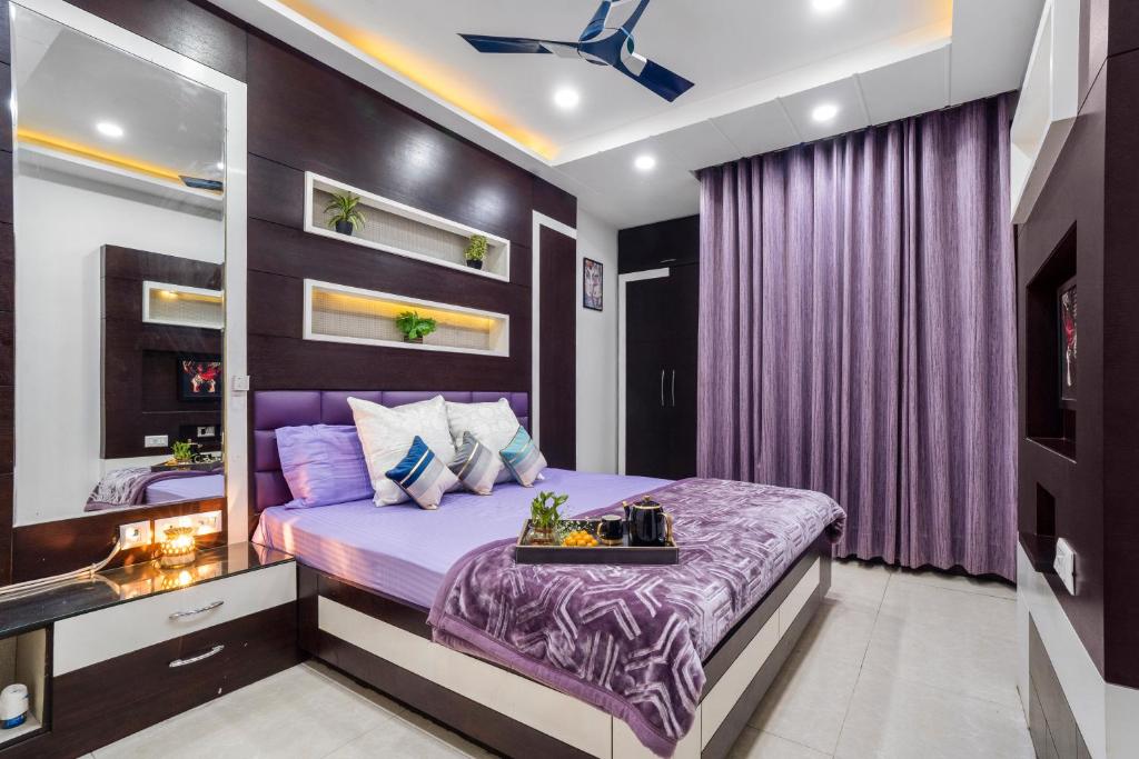 a bedroom with a purple bed and purple curtains at Homlee Villa Apartment with kitchen in East Delhi- Ghaziabad in Ghaziabad