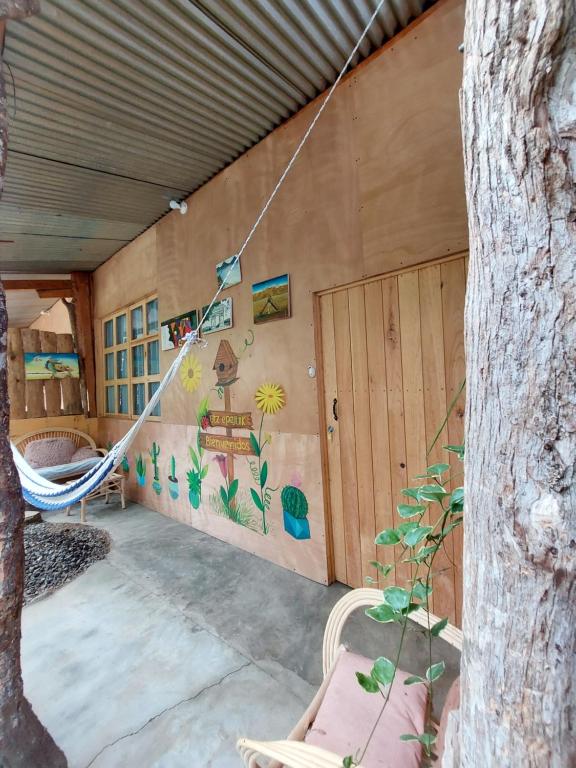 a porch with a hammock and a wall with a mural at Cabañas Maná in San Juan La Laguna