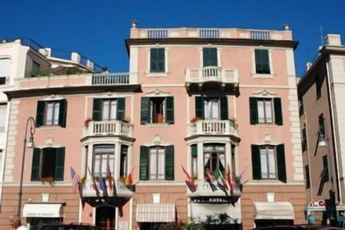 a large pink building with balconies on a city street at Hotel Fernanda in Rapallo