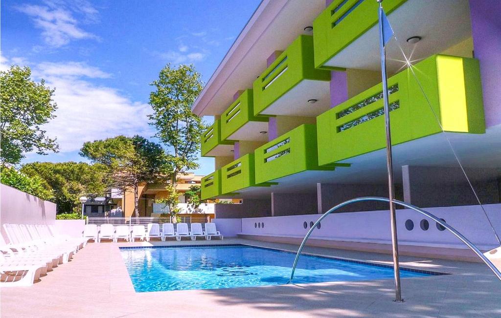 un edificio con piscina di fronte ad esso di Beautiful Apartment In Bibione With 1 Bedrooms, Wifi And Outdoor Swimming Pool a Bibione