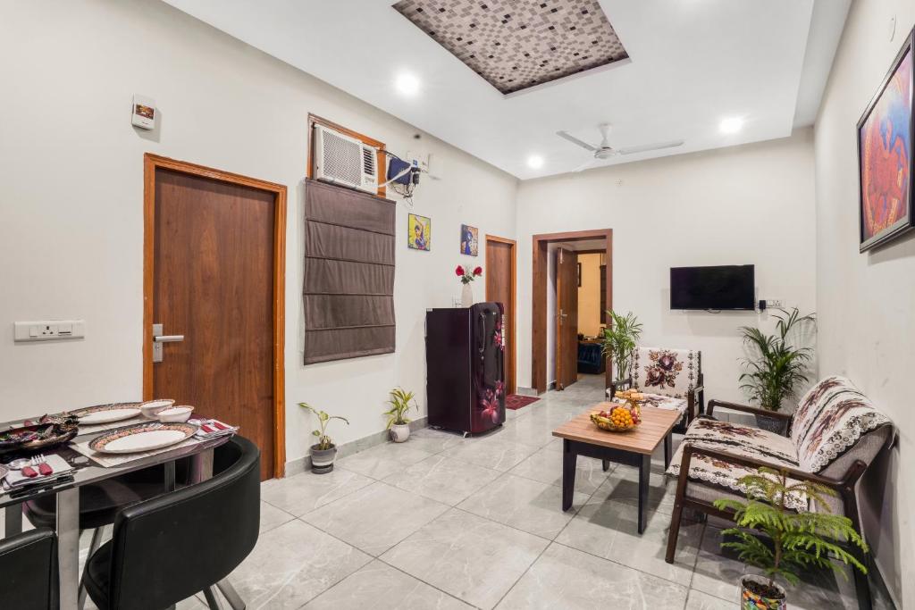 a living room with a table and chairs at Homlee-Luxurious 2BHK Apt with Kitchen near Metro in New Delhi