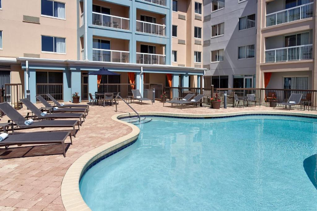 une piscine avec des chaises longues et un hôtel dans l'établissement Courtyard by Marriott Myrtle Beach Broadway, à Myrtle Beach