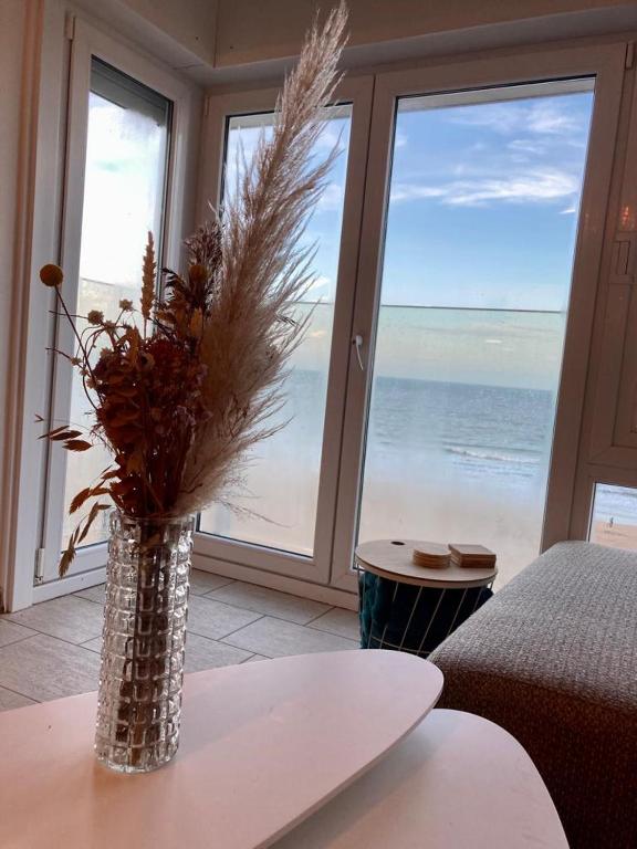 a vase of flowers sitting on a table in a living room at Appartement vue sur mer - Splendide localisation! in Sint-Idesbald