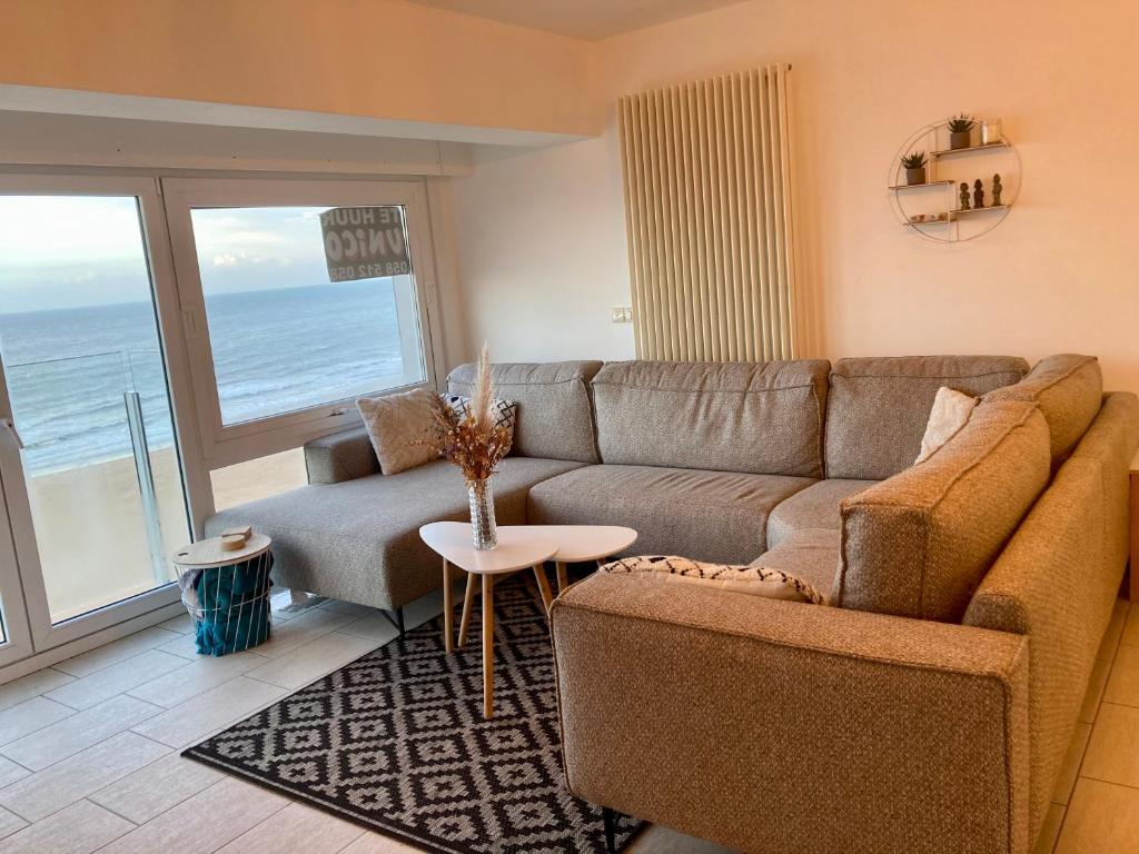 a living room with a couch and a table at Appartement vue sur mer - Splendide localisation! in Sint-Idesbald