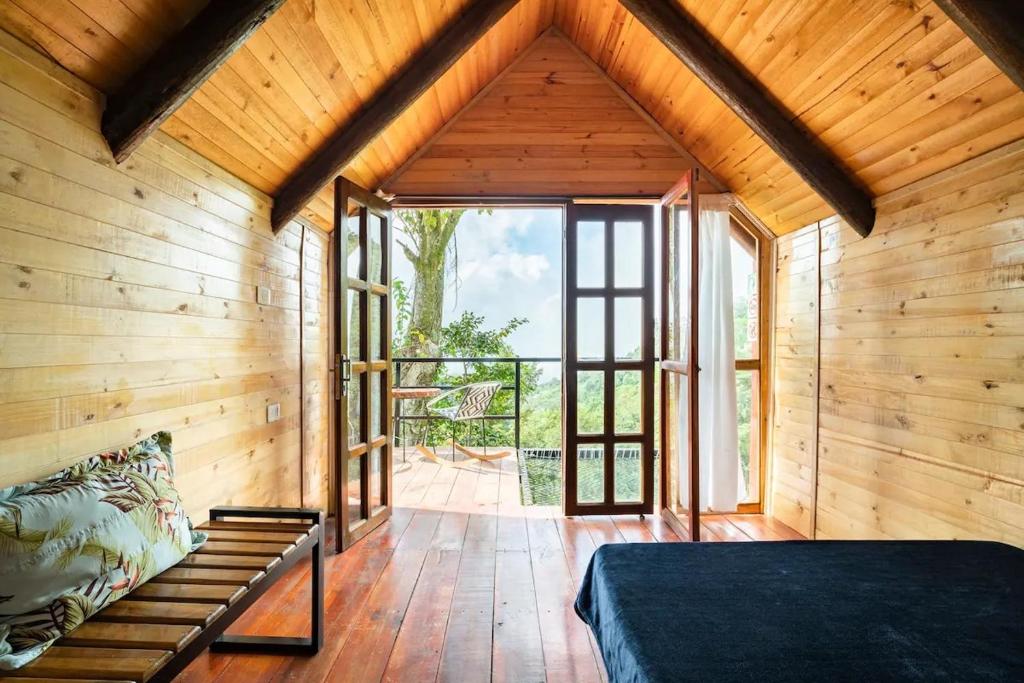 Habitación de madera con cama y balcón en Hostal Ana en Santa Marta