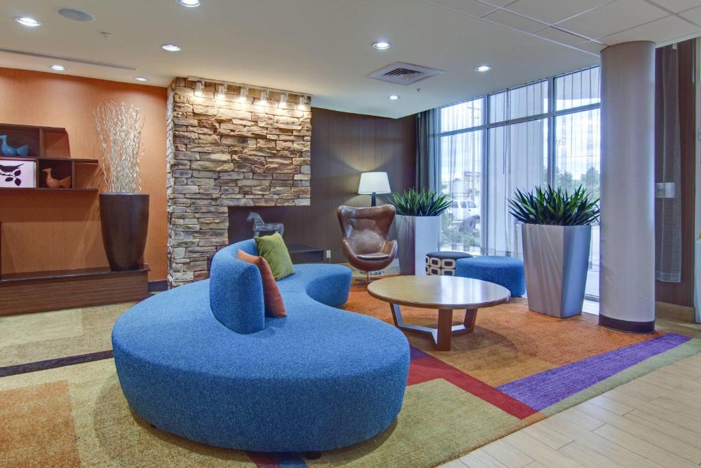 un vestíbulo con una silla azul, una mesa y una chimenea en Fairfield Inn and Suites by Marriott Natchitoches en Natchitoches