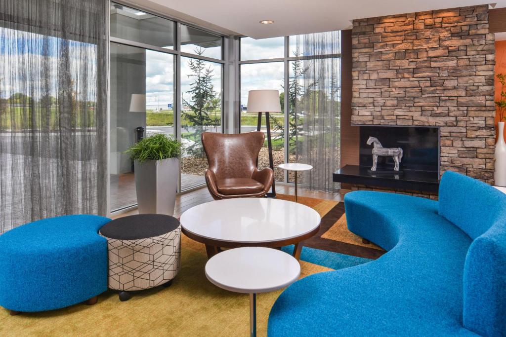 a living room with blue furniture and a fireplace at Fairfield Inn & Suites by Marriott Warrensburg in Warrensburg