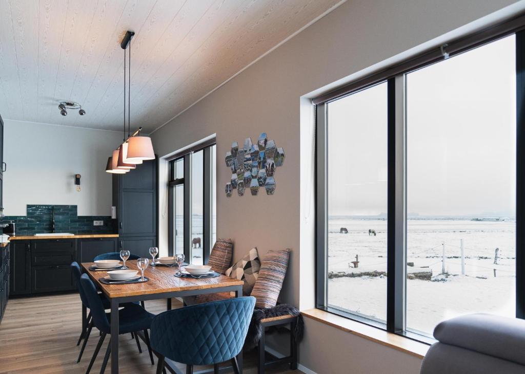 的住宿－Skidbakki Guesthouse，一间带桌椅和大窗户的用餐室