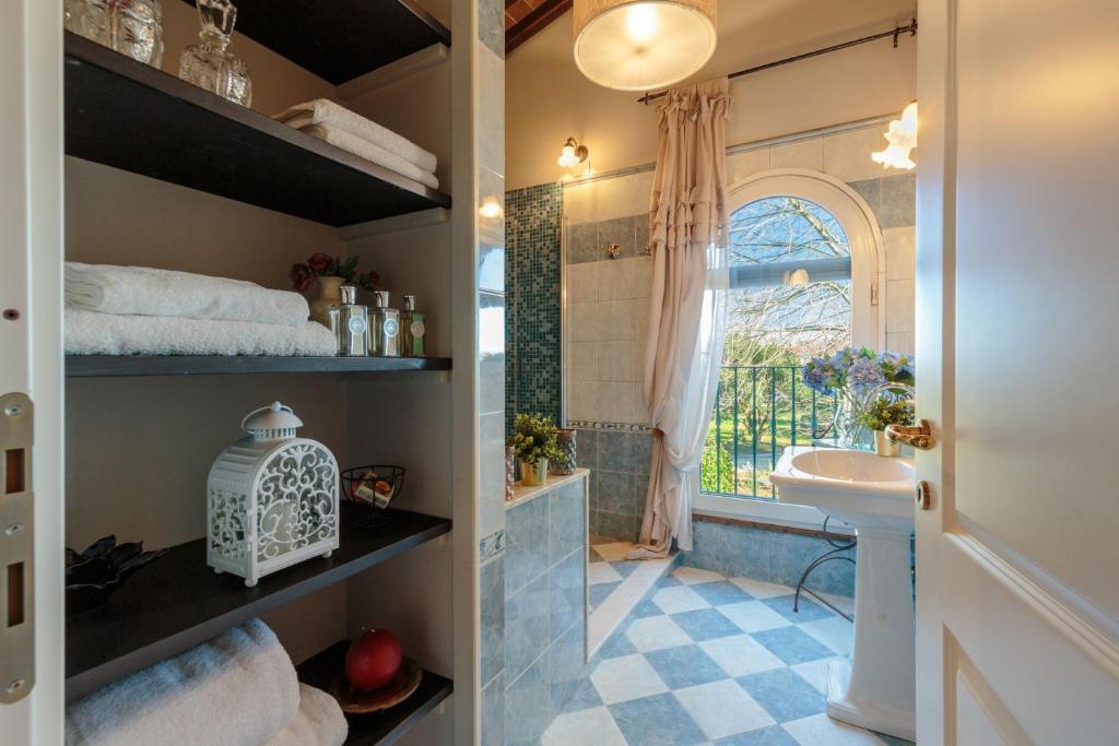 une salle de bain avec un lavabo et des toilettes et une fenêtre dans l'établissement Villa Catia Farmhouse, Three Luxury Bedrooms, a Jacuzzi Pool and a Dream-Like Getaway Experience, à Capannori 90 autres photos