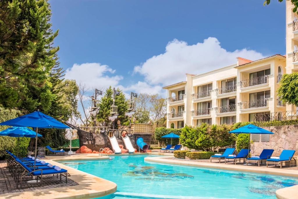 une piscine dans un hôtel avec des chaises et des parasols dans l'établissement Ixtapan de la Sal Marriott Hotel & Spa, à Ixtapan de la Sal