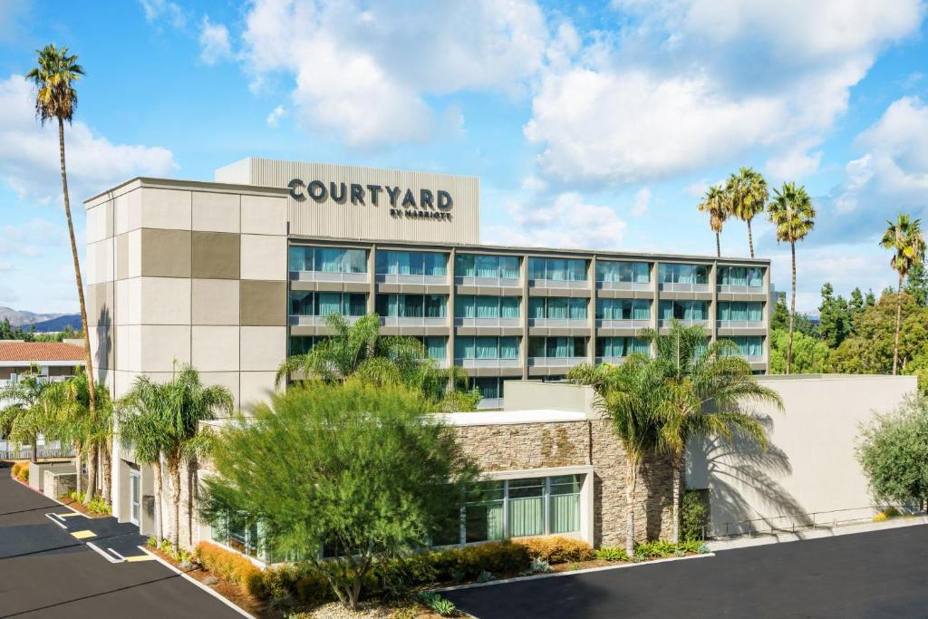 an exterior view of a hotel with palm trees at Courtyard by Marriott Los Angeles Woodland Hills in Woodland Hills