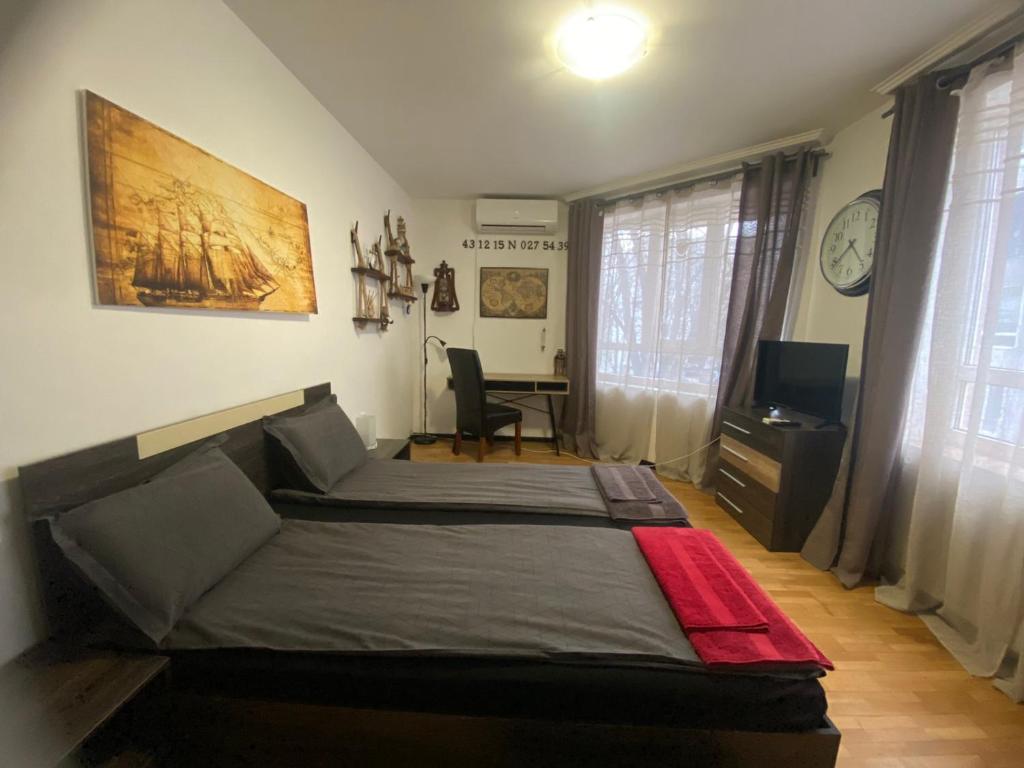 a bedroom with a bed and a desk in it at Apartament Bogoslovovi in Varna City