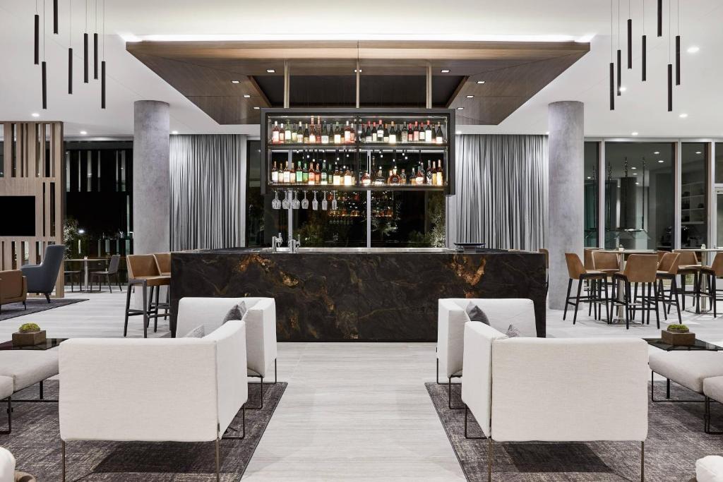 um átrio do hotel com um bar com cadeiras brancas em AC Hotel Phoenix Biltmore em Phoenix