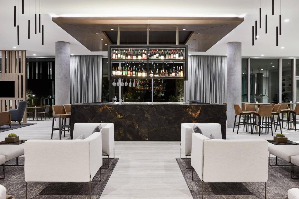 a hotel lobby with a bar with white chairs at AC Hotel Phoenix Biltmore in Phoenix