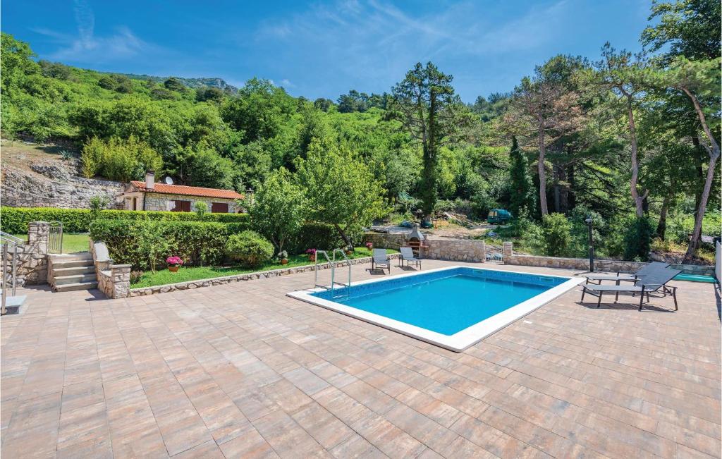 a patio with a swimming pool and a house at 3 Bedroom Amazing Home In Plomin in Plomin