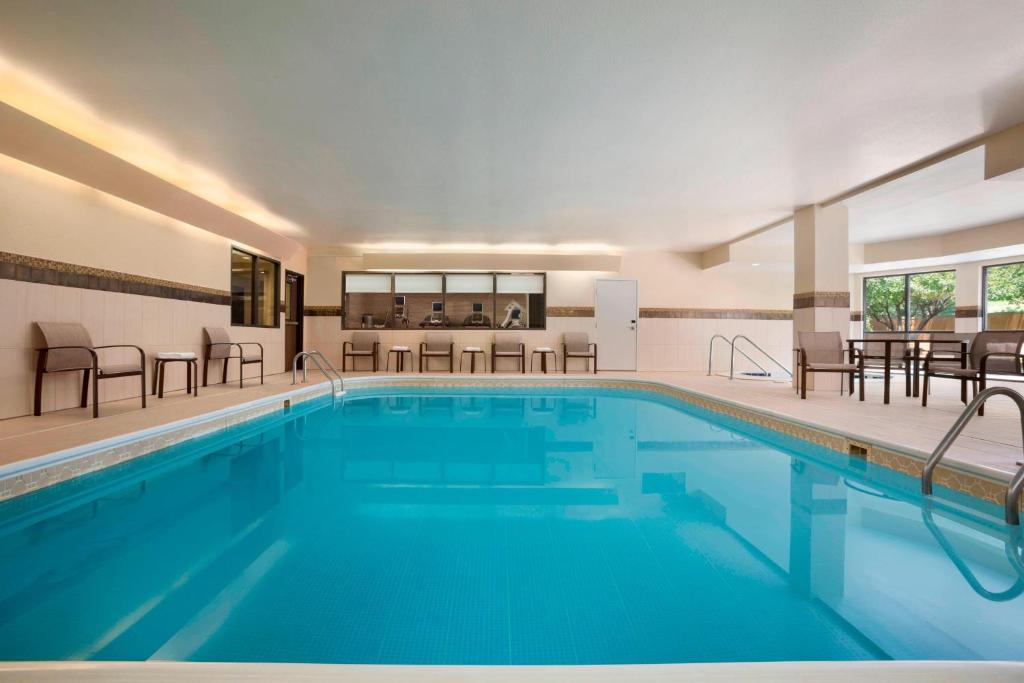 a pool in a hotel with chairs and tables at Courtyard by Marriott Springfield in Springfield