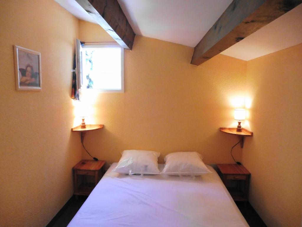 1 dormitorio con 1 cama con 2 lámparas en la pared en MAISONS DU GOLF Joli T3 villa mitoyenne proche plage Richelieu Cap d'Agde, en Cap d'Agde