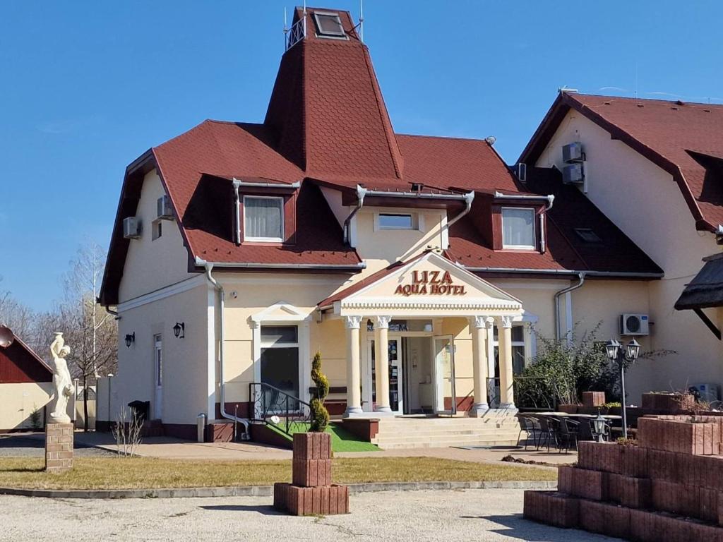 um grande edifício branco com um telhado vermelho em Liza Aqua & Conference Hotel em Lajosmizse