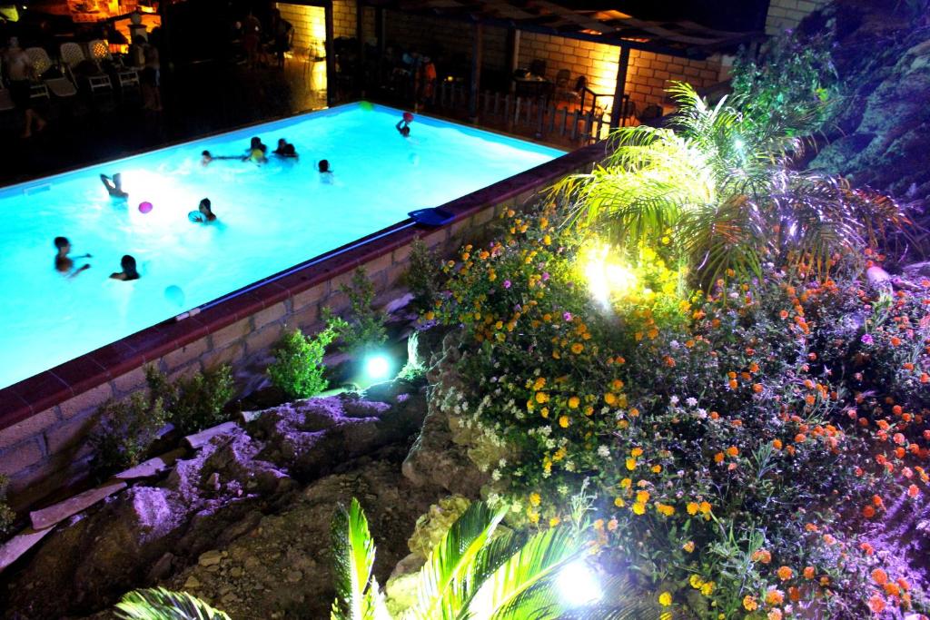 un grupo de personas nadando en una piscina por la noche en B&B Montemare, en Agrigento